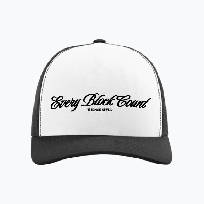 Front view close-up of the Every Block Count logo snapback cap, featuring a white base with elegant black script.