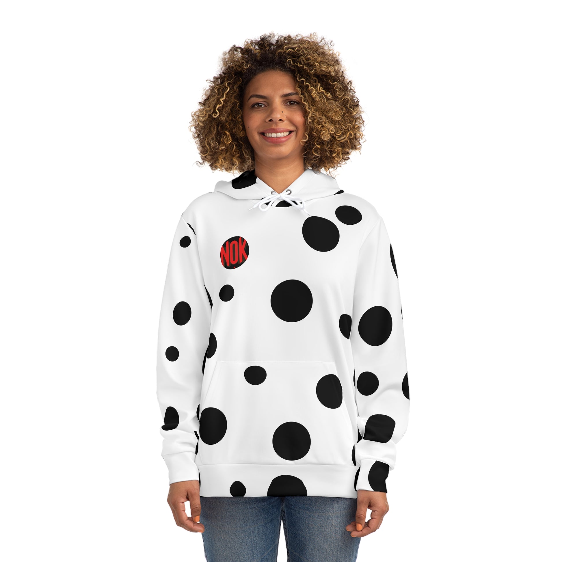 Front view of the white 'Break the Pattern' hoodie with bold black circular designs, worn by a smiling woman.