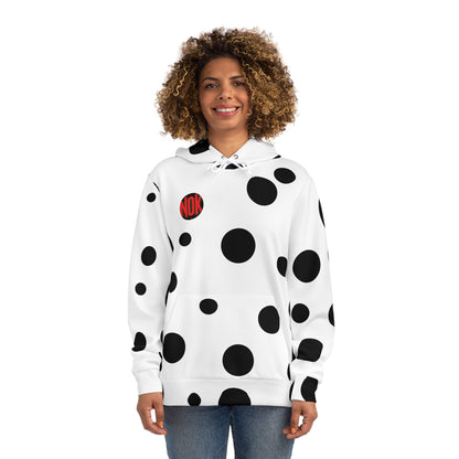 Front view of the white 'Break the Pattern' hoodie with bold black circular designs, worn by a smiling woman.