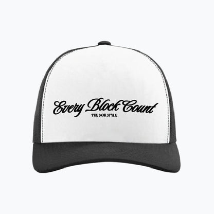 Front view close-up of the Every Block Count logo snapback cap, featuring a white base with elegant black script.