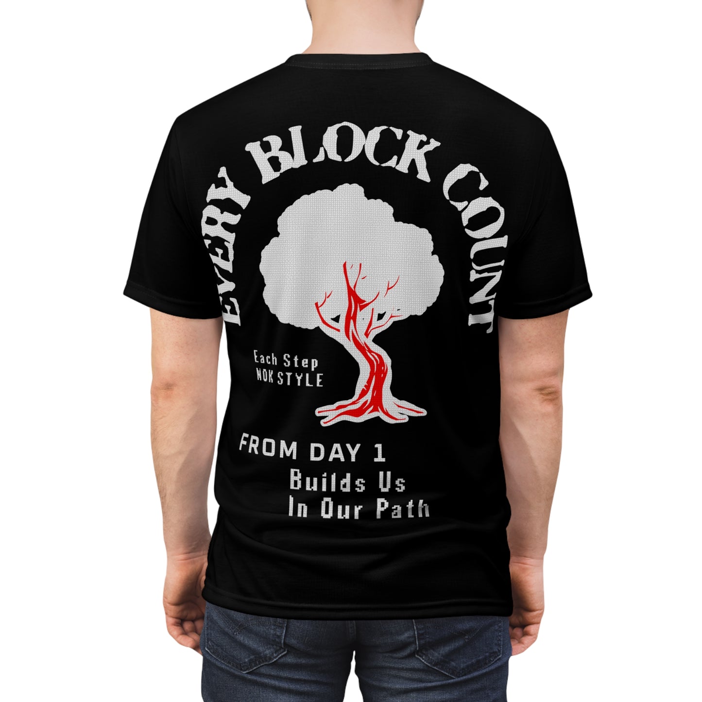 Rear view of a model wearing the Every Block Count black t-shirt featuring a red and white tree graphic and motivational text.