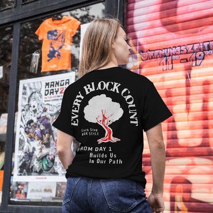 Model wearing the Every Block Count black t-shirt in an urban setting with bold rear graphic and motivational text.