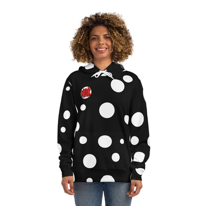 Front view of a woman in a black hoodie with bold white circular patterns, highlighted by the NOK logo on the chest.