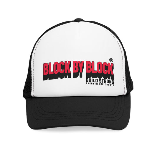 Front view of the Block by Block trucker cap with bold red text and the slogan 'Build Strong,' ideal for street-style fashion.