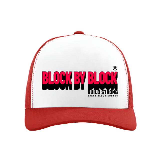 Front view of the Block by Block trucker cap with bold red text and the slogan 'Build Strong,' ideal for street-style fashion.