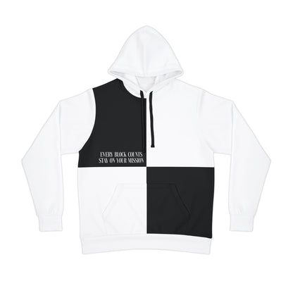 Flat lay of a white and black hoodie with a split color design and motivational text 'Every Block Counts. Stay on Your Mission.